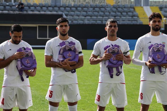 伊朗男足賽前手捧書(shū)包 悼念空襲遇難學(xué)生